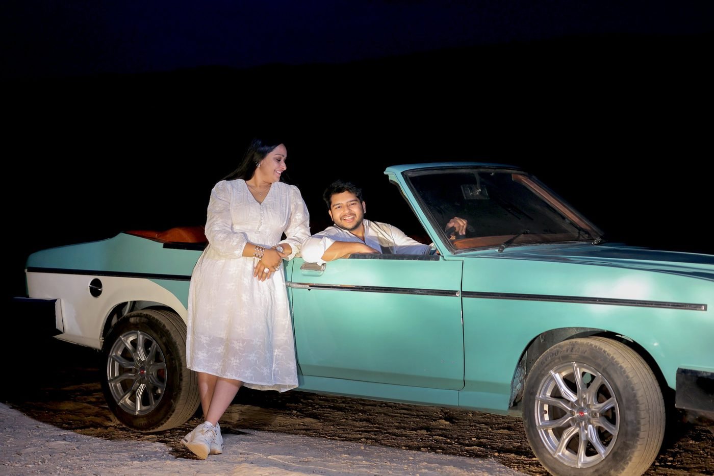 Couple with a blue Contessa vintage convertible at night, pre-wedding shoot in Udaipur