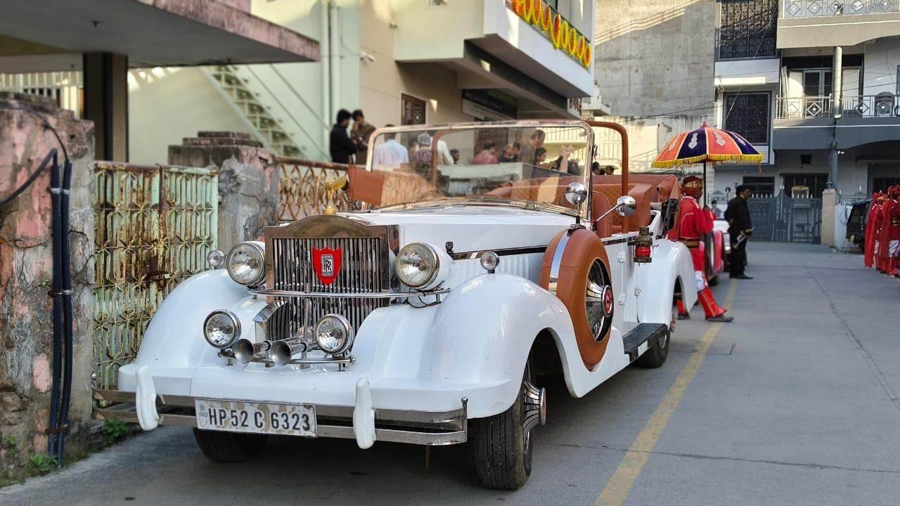 White Rolls-Royce style vintage car with traditional staff ready for a wedding in Udaipur
